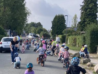 En masse børn der cykler på vejen 